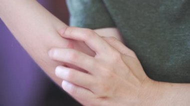 Kolu kaşınıyor, eli kaşınıyor ve kızarık bölgesinde kızarıklık ve rahatsızlık yaratıyor.