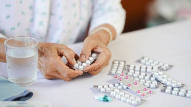 Yaşlılar için el hapları tableti. Su ve sağlık hizmetleri. Kapalı masa.