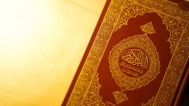 Kuran 'ın kapağını, İslam inancını ve ruhaniliğini sembolize eden kahverengi deri üzerindeki karmaşık Arap kaligrafisi ile kapatın..