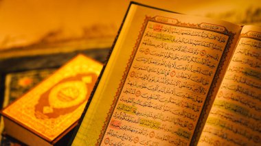 İslam namazı ve Ramazan ruhaniliği için sıcak ışıklandırma altında Kuran 'ın Arapça metin ve tajweed kurallarıyla kapatılması.