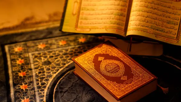 İslami kutsal kitap bir dua paspası ve açık bir sayfayla sergileniyor..