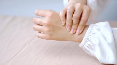 El ve cilt hassasiyetinde yumuşak doğal ışık ve yaralanma gösteren acı içinde bileğini tutan kişi.