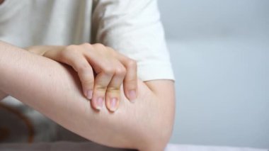 Genç Asyalı kadın üst koluna nazikçe masaj yapıyor kas gerilimi için kendini tedavi ediyor ve vücut bilincini arttırıyor.