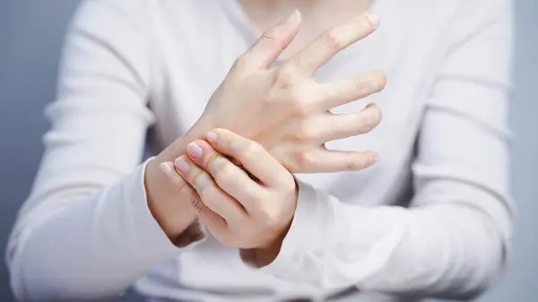 El ağrısı çeken bir kadın el bileği yaralanması. Sağlık sigortası. Elinde rahatsız edici bir kadın gömleği var.