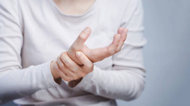 Kadının bileğine gergin bir ifadeyle masaj yapması eklem yaralanması ya da tekrarlayan stres sendromu olduğunu gösteriyor..