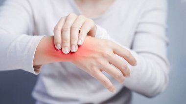 Kırmızı tahriş olmuş bilek bölgesine dokunmak iltihaplanma deri tepkisini ya da ağrı semptomlarını temsil eder..