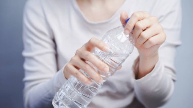 Eller plastik su şişesini açarak kavrama gücünü, motor işlevini ve el becerisini vurguluyor..