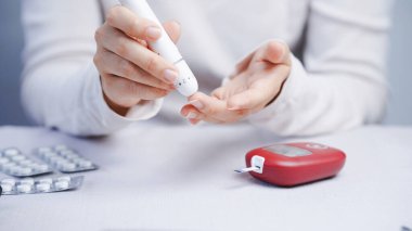 Kan şekeri ölçeri, kan şekeri seviyesi, diyabet yönetimi, sağlık konsepti kullanan bir kişi