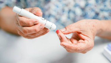 Evde diyabet kontrolü için kan şekeri seviyesini ölçmek için yaşlı ellerde neşter ve dikenli parmak bulunur..