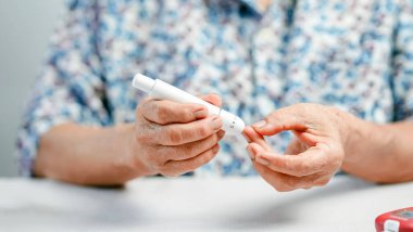 Evde kan şekeri seviyesini kontrol etmek için beyaz mızrak kullanan yaşlı kişi şeker kontrolü ve sağlık bilincini kontrol ediyor..