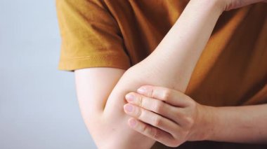 Dirseğini tutan, eklem ağrısı, yaralanma, eklem iltihabı veya tendon iltihabı tasvir eden kişinin yakın çekimi, tıbbi, sağlık, sağlık ve fizyoterapi içeriği için idealdir..