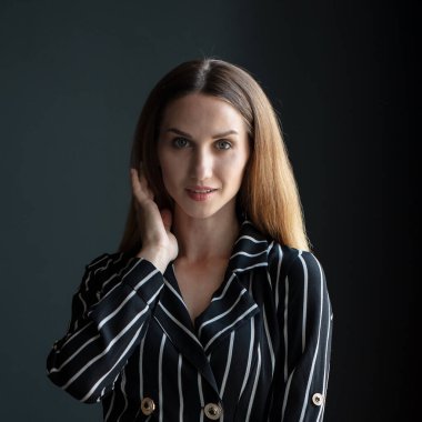 Genç, güzel esmer, siyah çizgili elbiseli, odada poz veren.