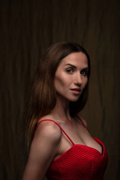 Hermosa Joven Morena Posando Vestido Rojo Sobre Fondo Marrón Oscuro — Foto de Stock