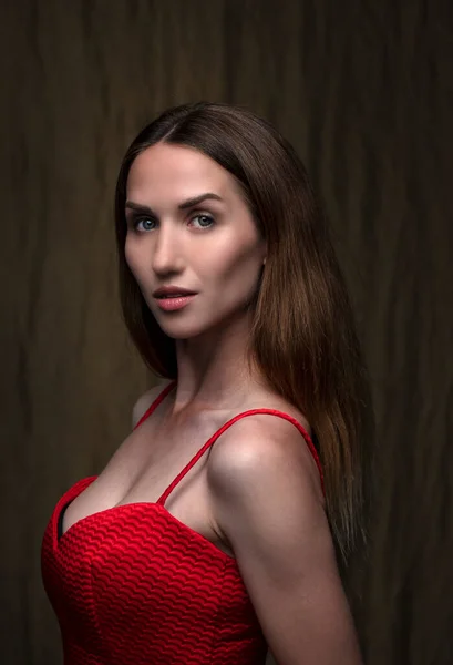 Hermosa Joven Morena Posando Vestido Rojo Sobre Fondo Marrón Oscuro —  Fotos de Stock
