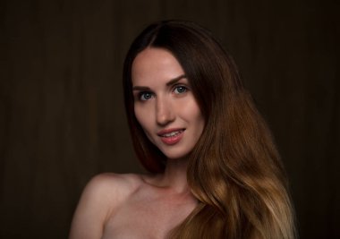 Makyajlı gülümseyen kadın kameraya gülümsüyor.