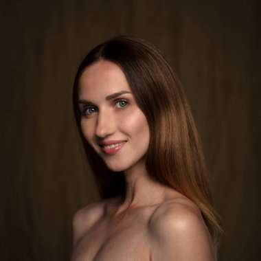 Makyajlı gülümseyen kadın kameraya gülümsüyor.