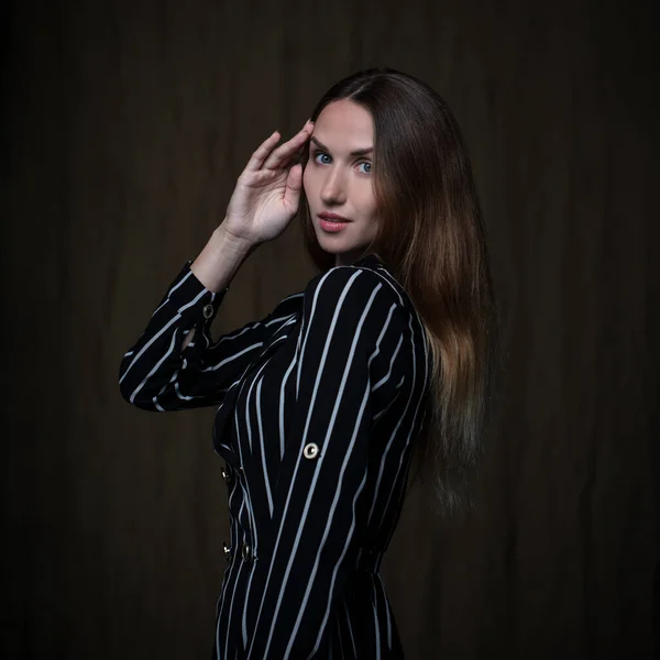Woman with long hair posing wearing striped dress