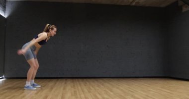 Spor salonunda egzersiz yapan bayan sporcu.