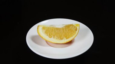  Siyah arkaplanda dönen portakal dilimi.