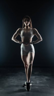 Beyaz iç çamaşırlı güzel atletik kadın stüdyoda poz veriyor.