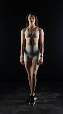 Karanlıkta ağırlık kaldıran kadın.