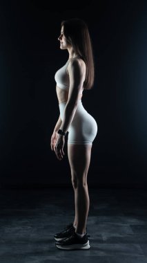 Stüdyoda poz veren genç atletik kız.