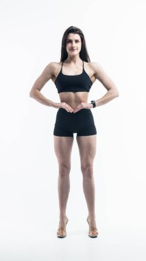 Siyah iç çamaşırlı, gülümseyen bir kadının tam boy portresi. Gri arka plandaki kameraya bakıyor. Stüdyo çekimi, kopyalama alanı.