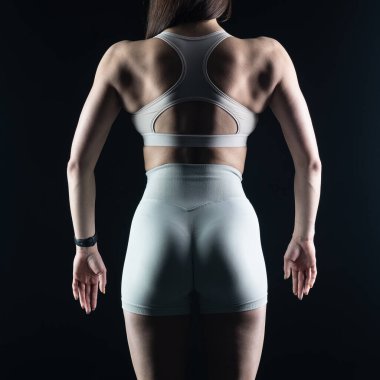 Stüdyoda poz veren genç atletik kadın.