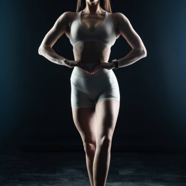 Genç bir kadın karanlık arka planda egzersiz yapıyor. fitness ve sağlık hizmeti kavramı.