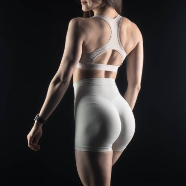 Stüdyoda beyaz iç çamaşırlarıyla poz veren genç bir kız..