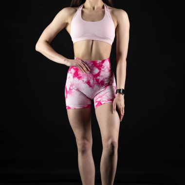 Spor kıyafetli genç bir kadın poz veriyor.