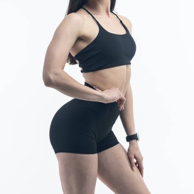 Beyaz bir arka planda poz veren siyah elbiseli güzel bir kadın.