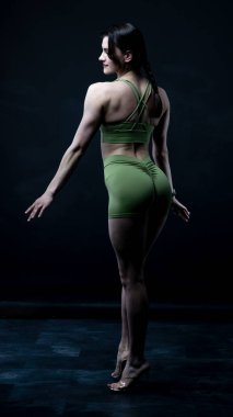 Siyah arka planda mayo giymiş genç ve güzel bir kadın..