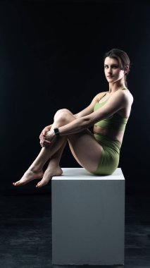 Siyah bir arka plana karşı poz veren güzel ve genç bir kadın. Stüdyo çekimi..