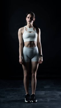 Beyaz elbiseli kadın stüdyoda poz veriyor.