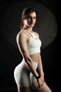 Genç kadın siyah arka plan üzerine poz.