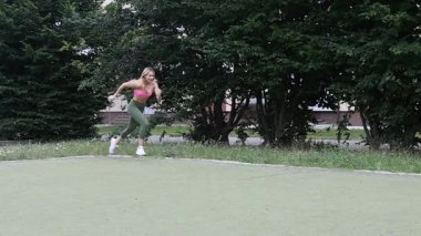 Kız parkta spor yapıyor.