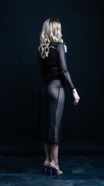 Stüdyoda siyah iç çamaşırlarıyla poz veren güzel bir kız.