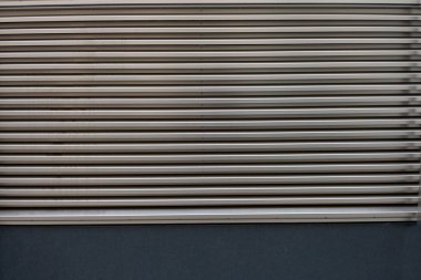 Arka plan olarak kullanılacak yatay bölümleri olan gümüş gri metal alüminyum havalandırma ızgarasının kısmi görüntüsünü kapat