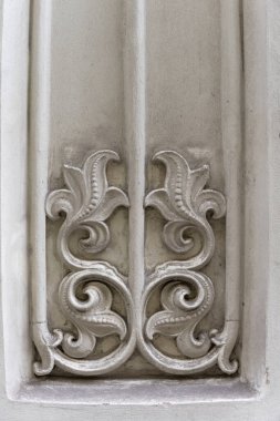 Arkaplan olarak kullanmak üzere güzel dekore edilmiş çiçek desenli tarihi bir binanın eski taş cephesini kapatın.