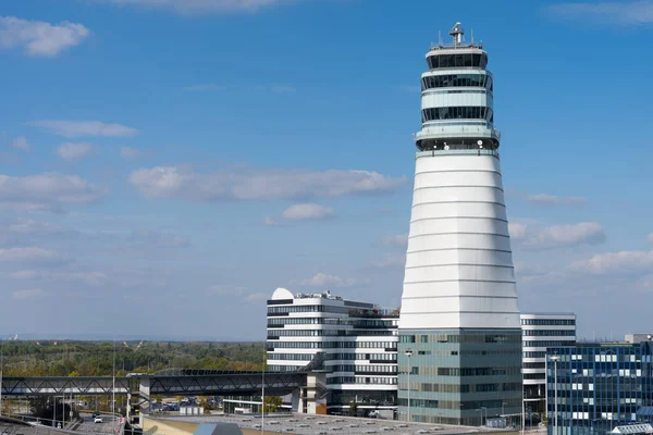 Vienna airport with high tower of air traffic control and various logistics buildings in front of blue sky