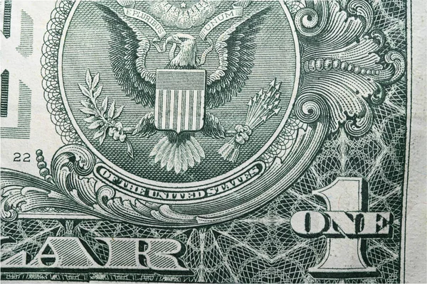 Extreme close up detail of emblem one dollar banknote with clearly visible American eagle laurel branches and arrows with inscription trust as concept for American history money economy and war power