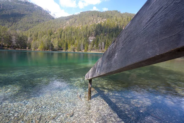 チロルの澄んだ山の湖とフェンスの広い角度のショットは 手付かずの自然の中で泳ぐための水の招待状につながり 観光休暇や休暇のための概念 — ストック写真