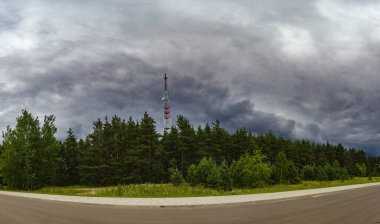Arka planda orman ve mobil kule antenli yağmur bulutlarının görüntüsü