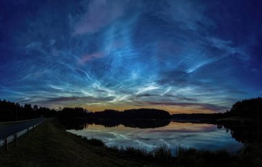 Gölün üzerinde gün doğumu ve gece bulutları