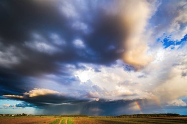 Gökyüzünde fırtına bulutları, ufukta yağmur, yaz mevsimi. İki gökkuşağı