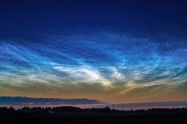 Gece parlayan bulutların çarpıcı bir görüntüsü alacakaranlık gökyüzünde parıldıyor.. 