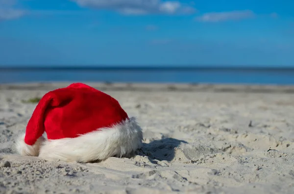 Christmas vacation at sea. Santa hat, starfish, coctail on sandy beach.Christmas card and advent calendar concept. Travel ticket sale concept for christmas holidays.Copy space.Close up.High quality