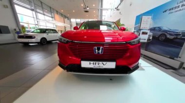 Honda HR-V kırmızı renk 2022, Letonya 'da bir araba galerisi Honda' da satışa sunuldu. Ön görüş. Yüksek kaliteli FullHD görüntüler