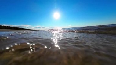 Baltık Denizi 'nin dalgaları kumlu sahile doğru akıyor. Yavaş çekimde yakın çekim. Rahatlama konsepti. Yüksek kaliteli FullHD görüntüler